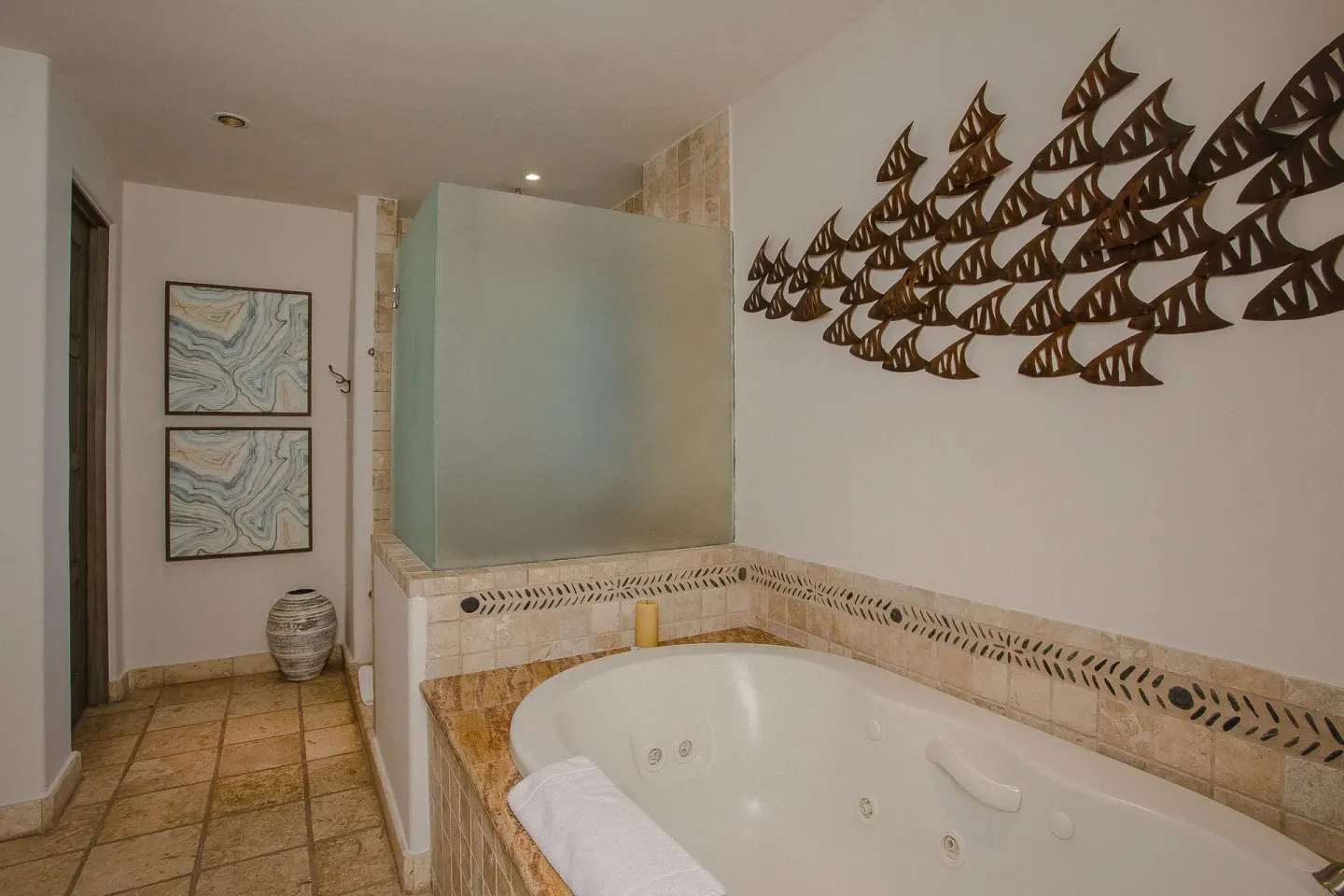 Jetted tub with tile surround and wall art in a Casona garden view room at Esperanza.