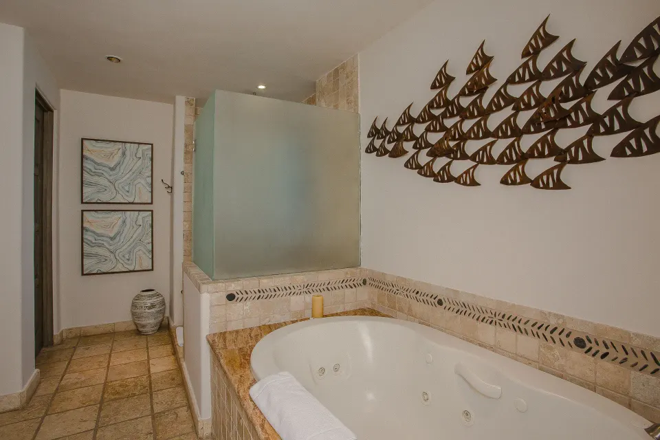 Jetted tub with tile surround and wall art in a Casona garden view room at Esperanza.