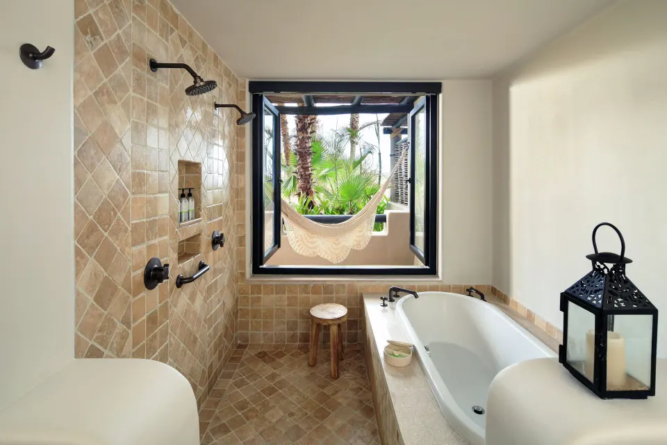Ocean View casita bathroom at Esperanza with tub, tiled shower and window to a hammock.