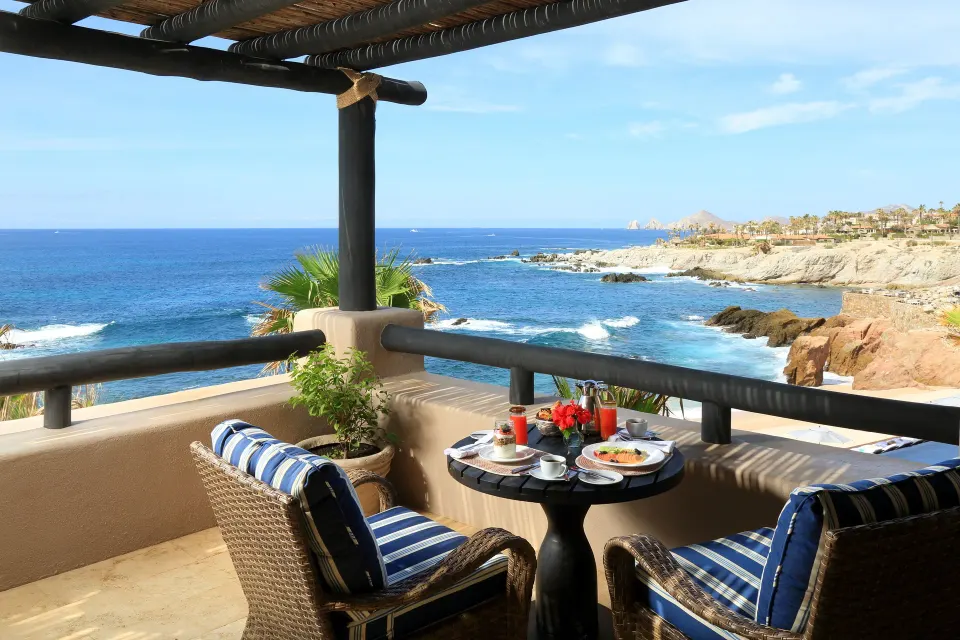 Studio Ocean View terrace with breakfast table and coastline at Esperanza.