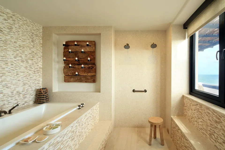 Penthouse Spa Suite bathroom with soaking tub, shower, and ocean view at Esperanza.