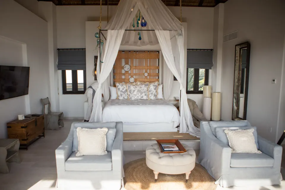 Penthouse Spa Suite canopy bed with two lounge chairs at Esperanza.