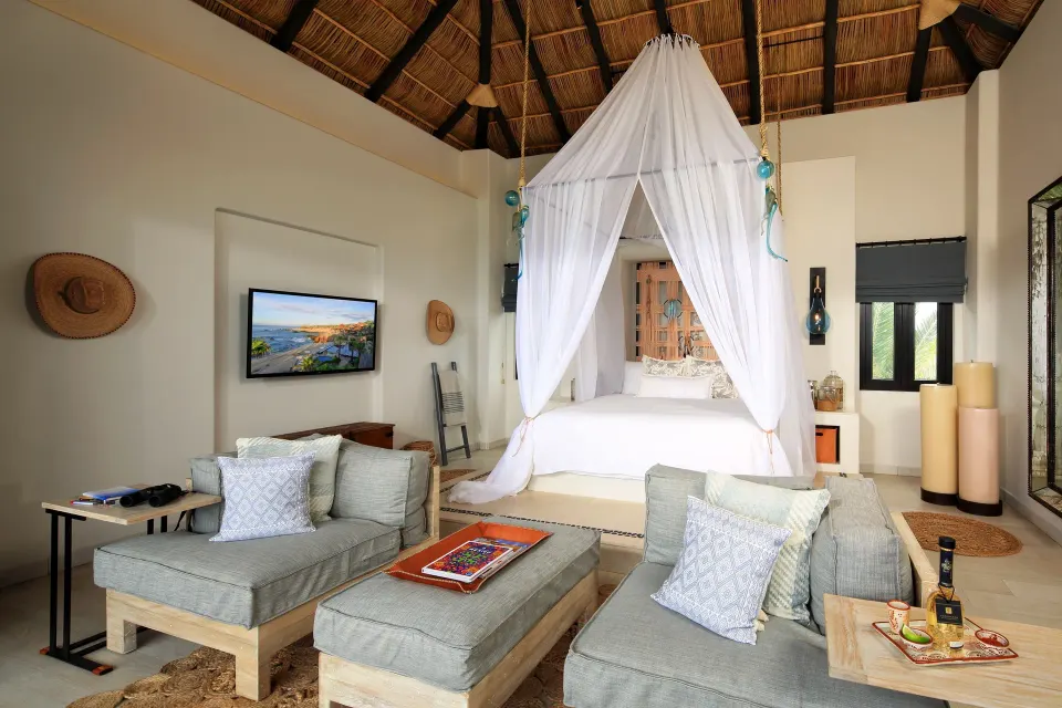 Penthouse Spa Suite bedroom and lounge with canopy bed at Esperanza.