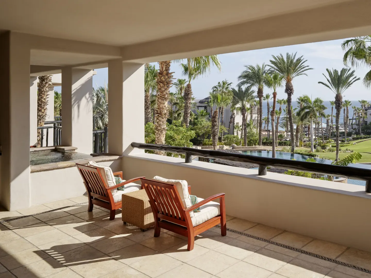 Two Bedroom Garden View Villa terrace with chairs and palm garden views at Esperanza.