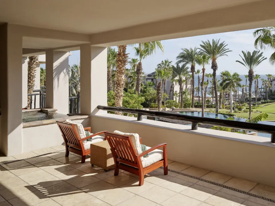 Two Bedroom Garden View Villa terrace with chairs and palm garden views at Esperanza.