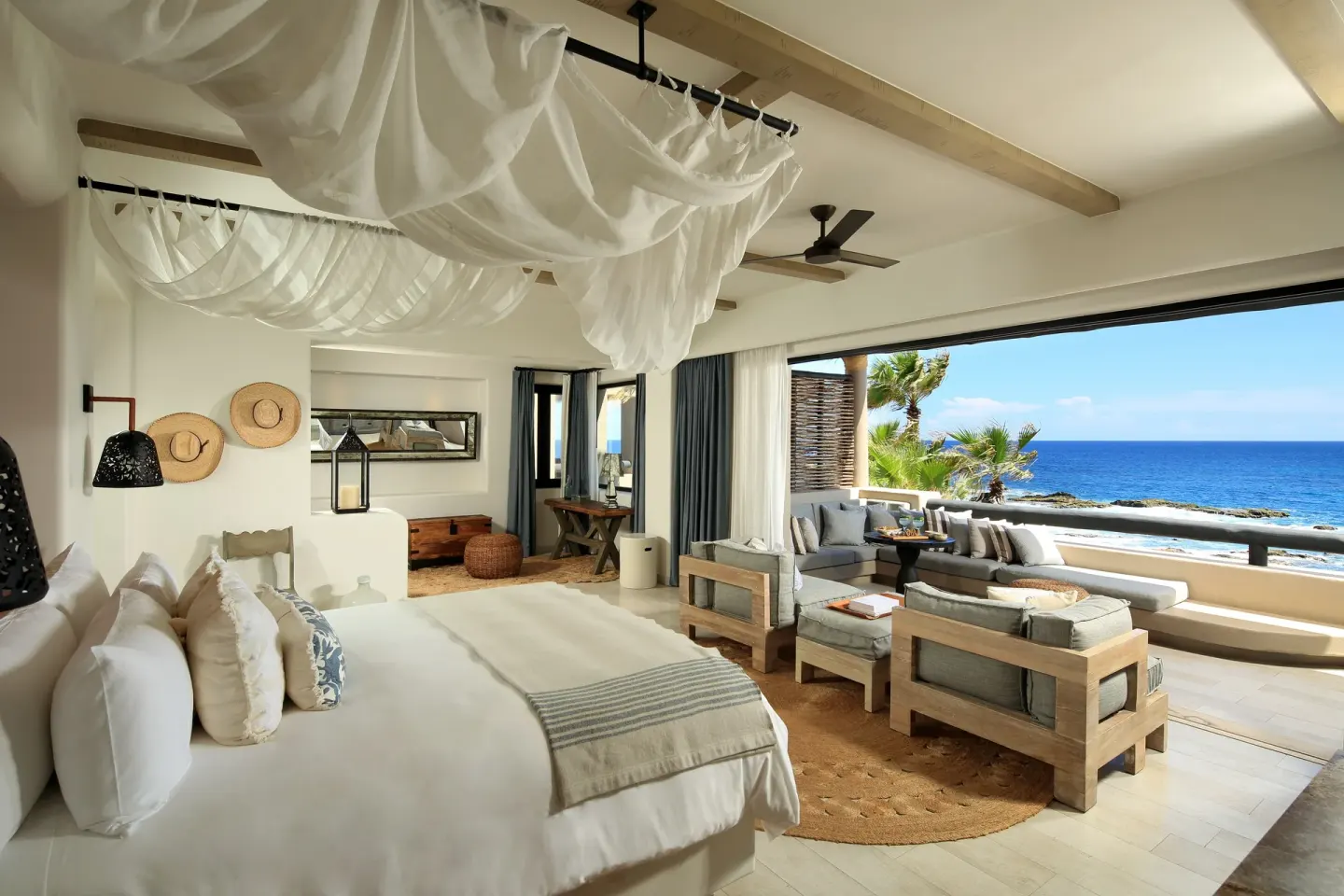 Villa bedroom with king bed, draped canopy, and oceanfront terrace at Esperanza.