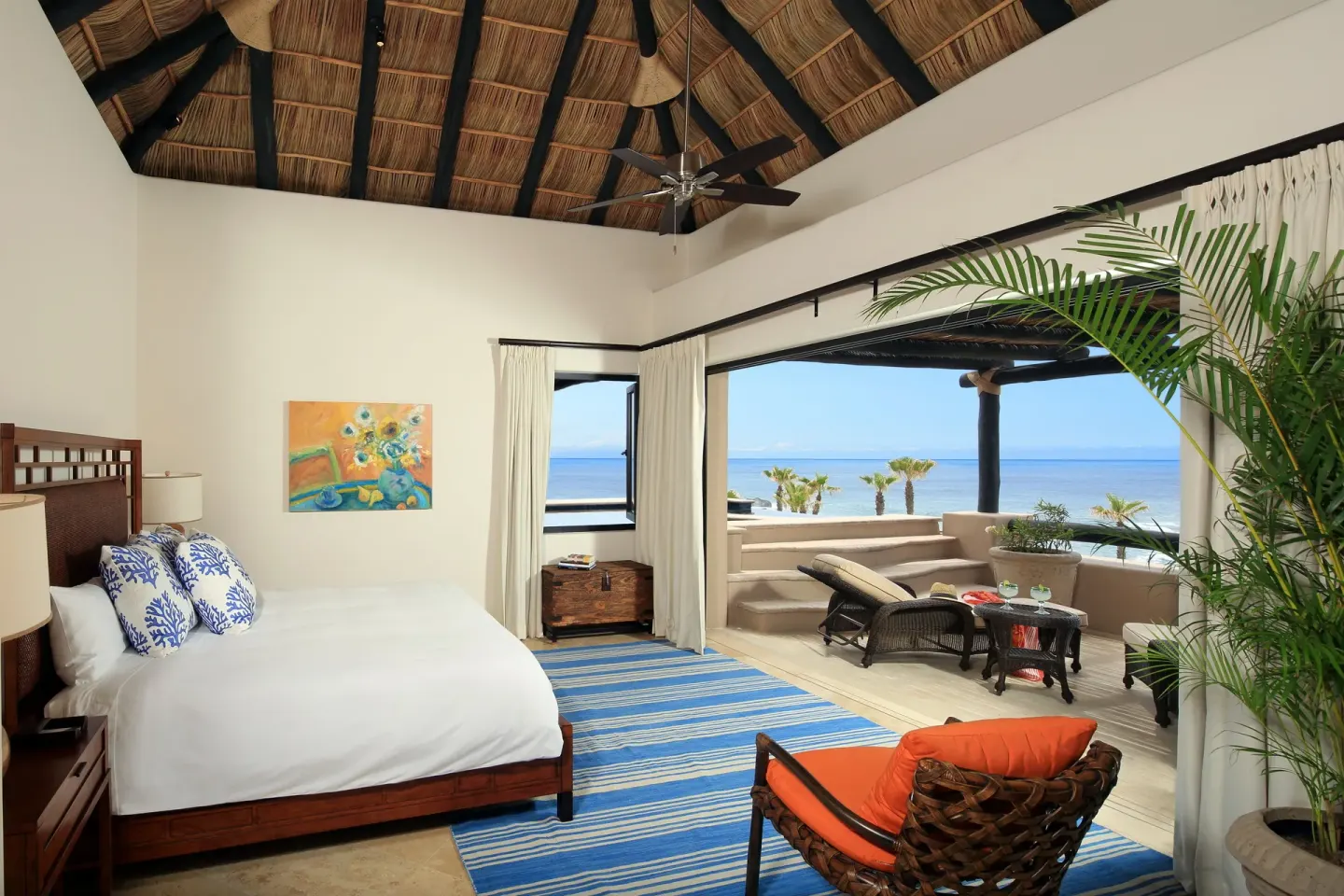 Villa bedroom with king bed, vaulted ceiling, and covered ocean terrace at Esperanza.