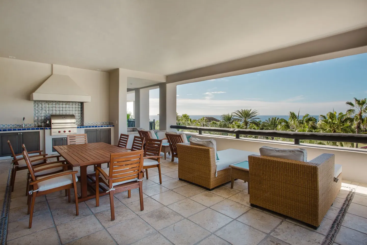 Covered terrace with dining table, lounge seating, and ocean view at Esperanza.