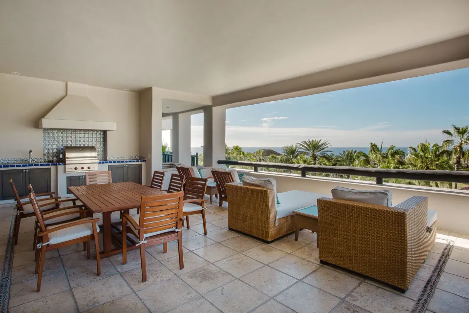 Covered terrace with dining table, lounge seating, and ocean view at Esperanza.
