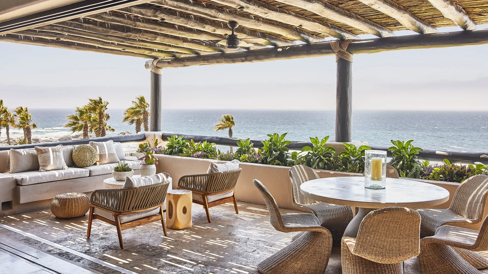 Oceanfront villa terrace with dining table and lounge seating at Esperanza.