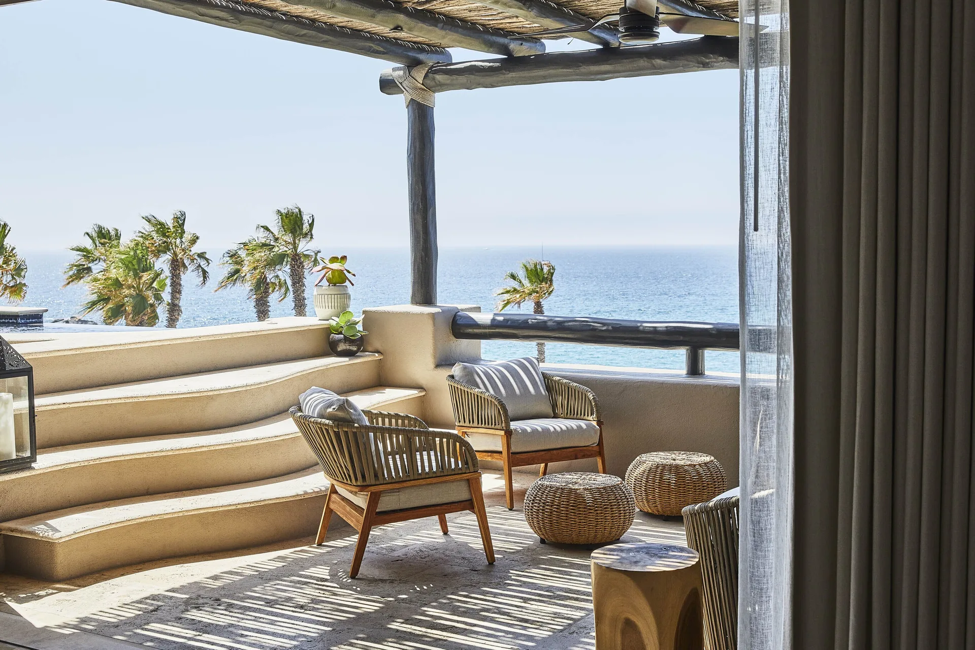 Shaded oceanfront villa terrace with wicker chairs at Esperanza.