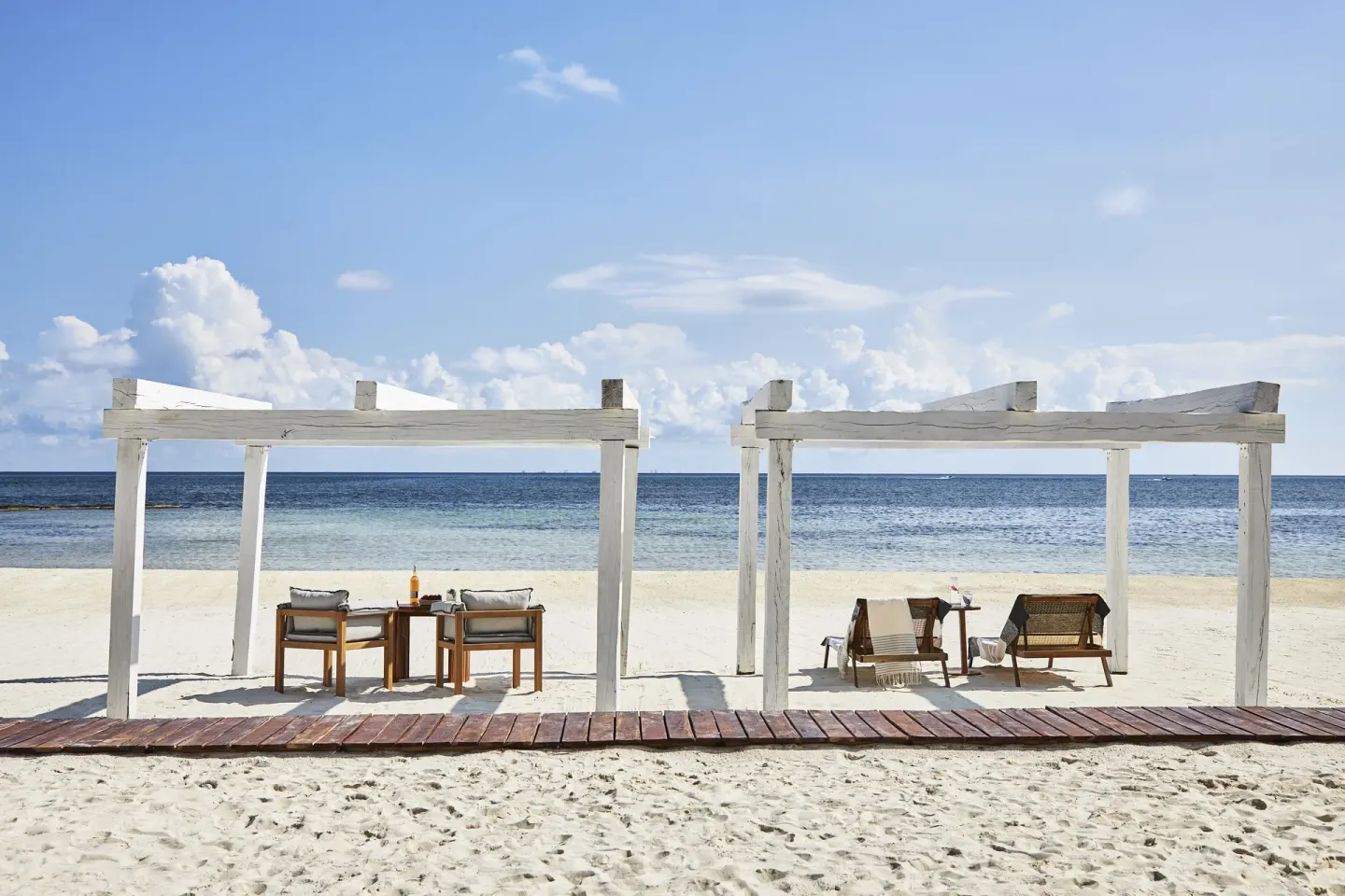 White beach cabanas with lounge chairs facing the ocean at Etéreo, Auberge Collection.