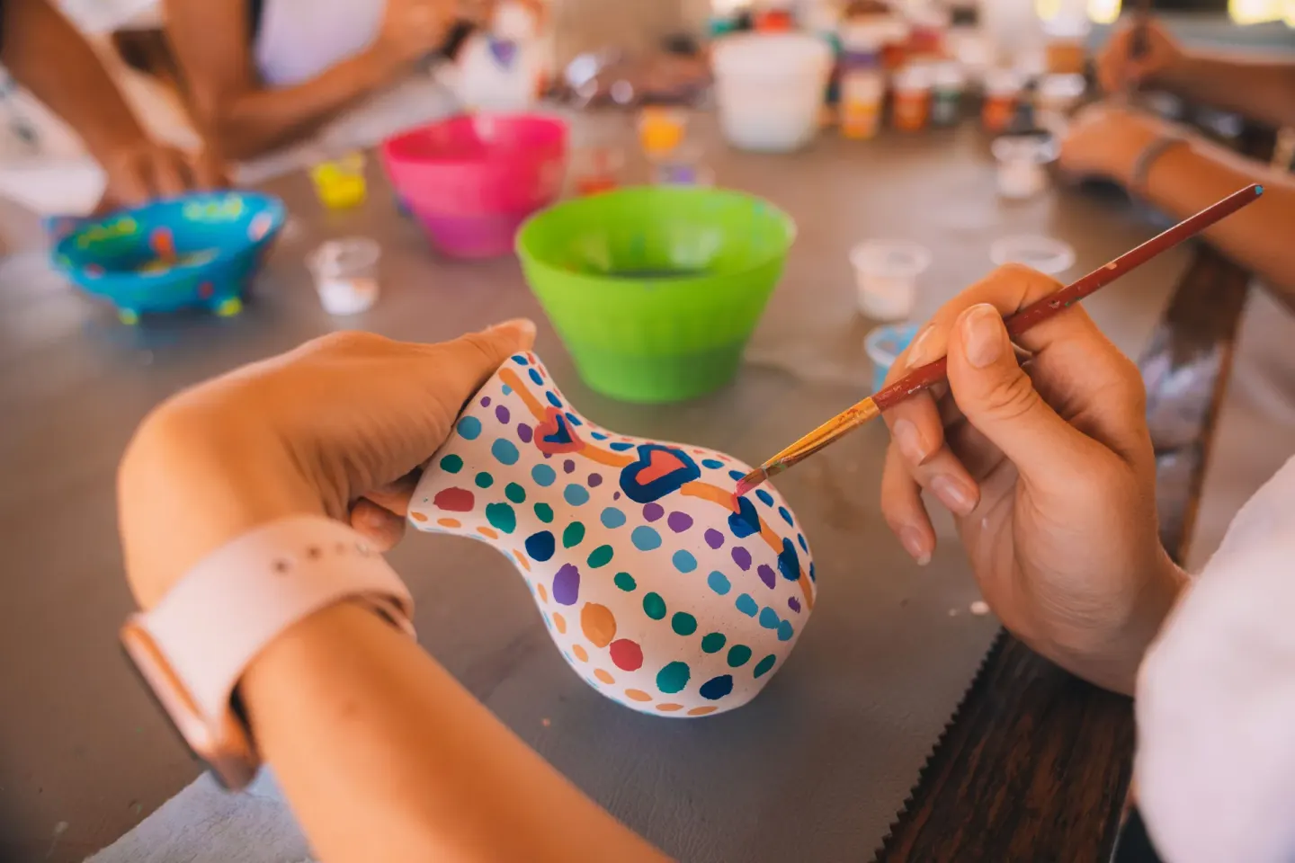 A guest paints a colorful ceramic vase at Etéreo, Auberge Collection.