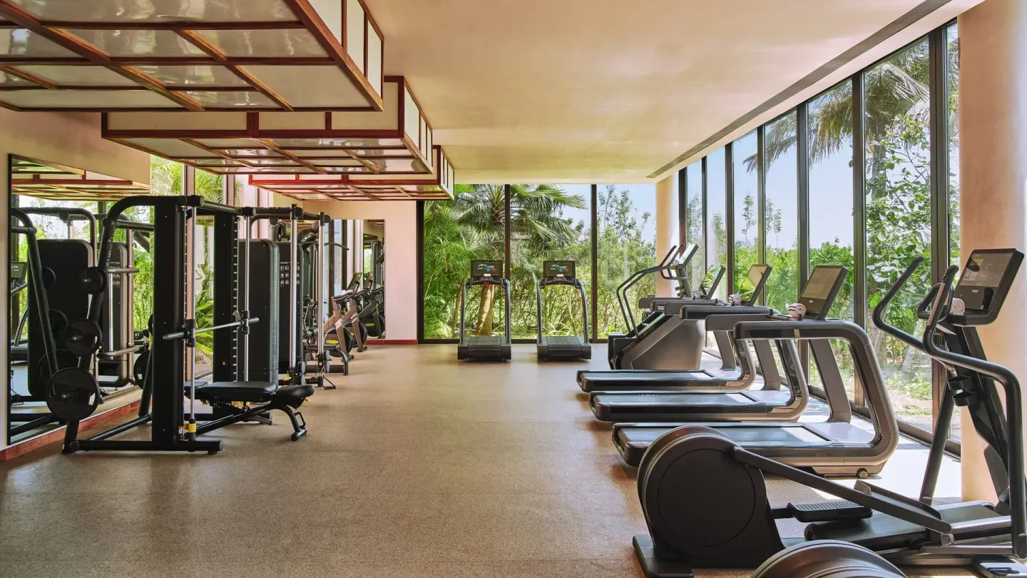Fitness center with cardio machines, weights, and garden views at Etéreo, Auberge Collection.