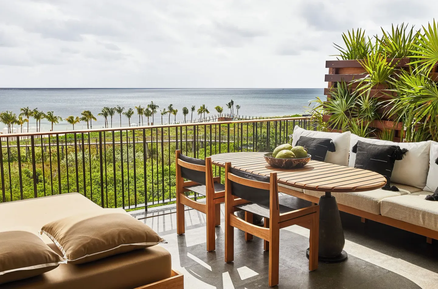 Ocean-view terrace with dining table and cushioned seating at Etéreo, Auberge Collection.