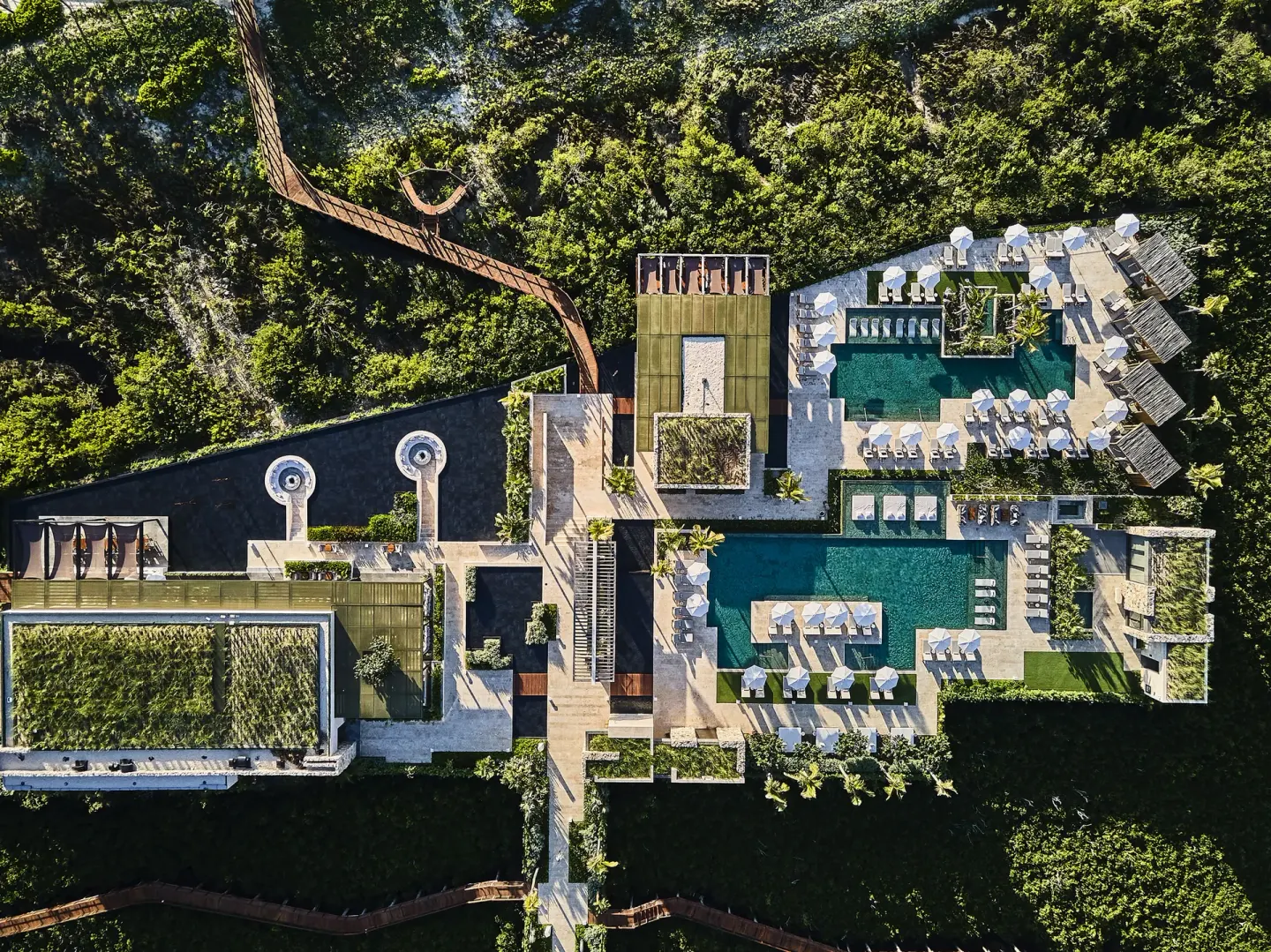 Overhead view of pools, loungers, rooftops and mangrove paths at Etéreo, Auberge Collection.
