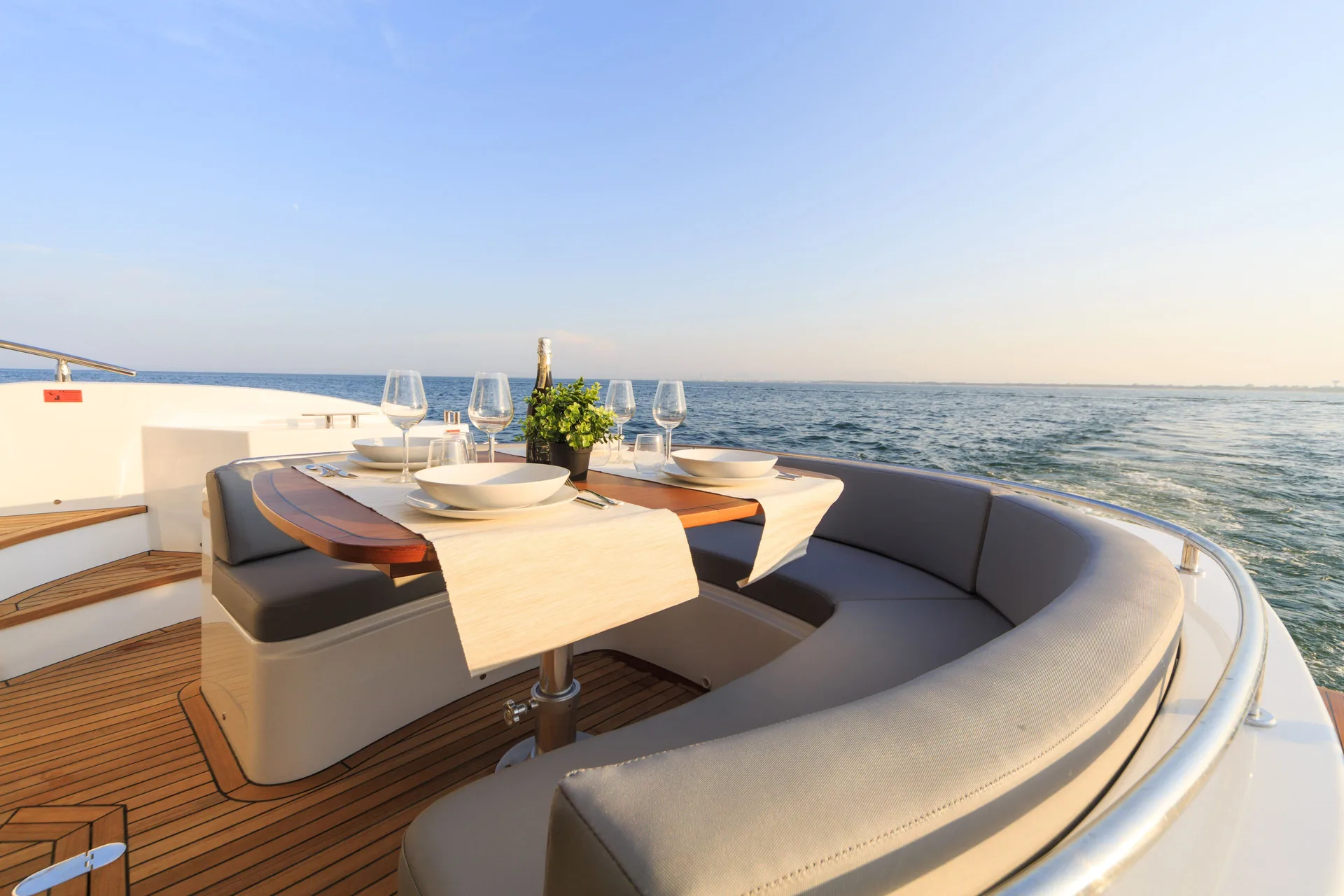 A set dining table on a yacht deck at sunset near Etéreo, Auberge Collection.