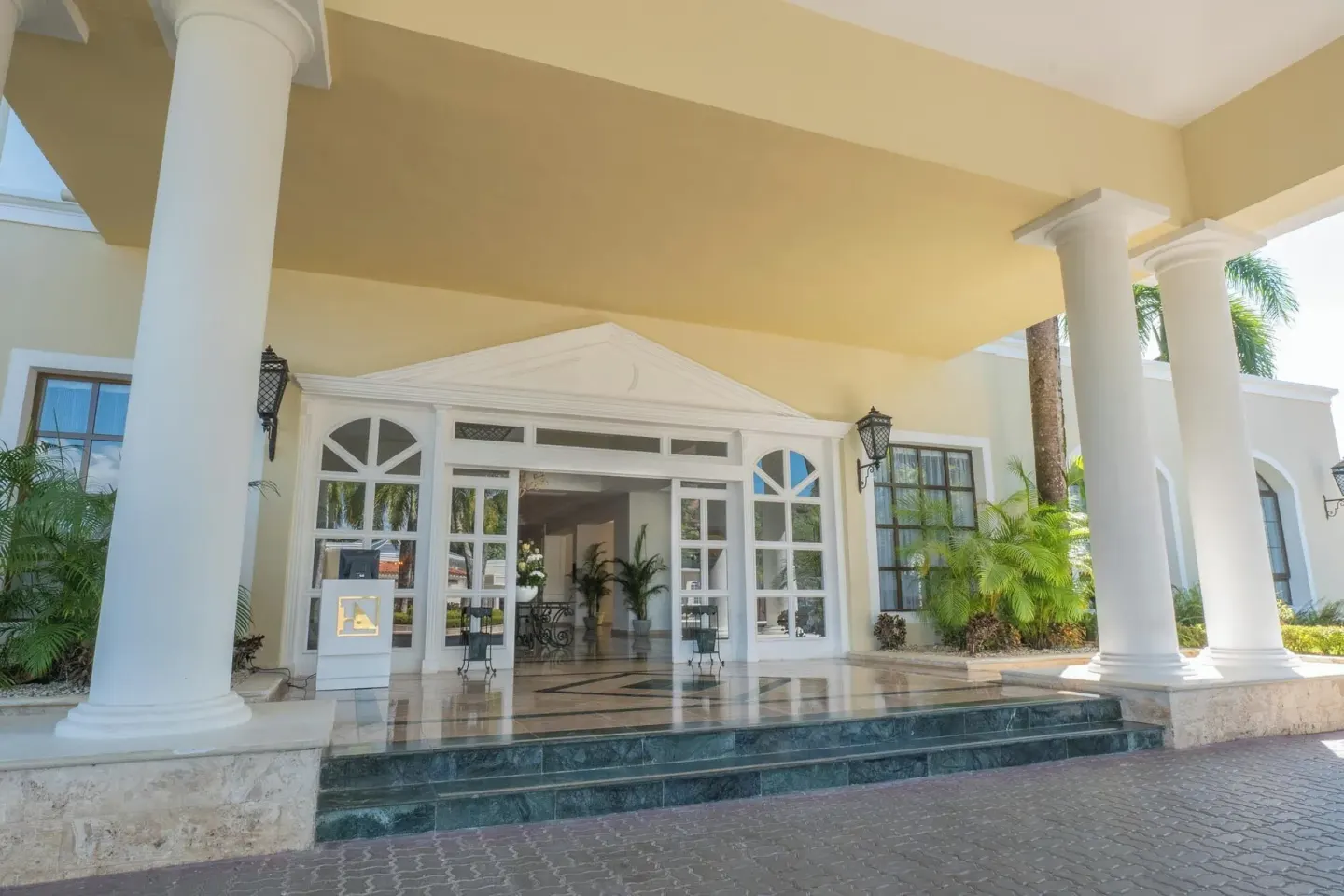 Covered front entrance with white columns at Eurostars Grand Cayacoa.