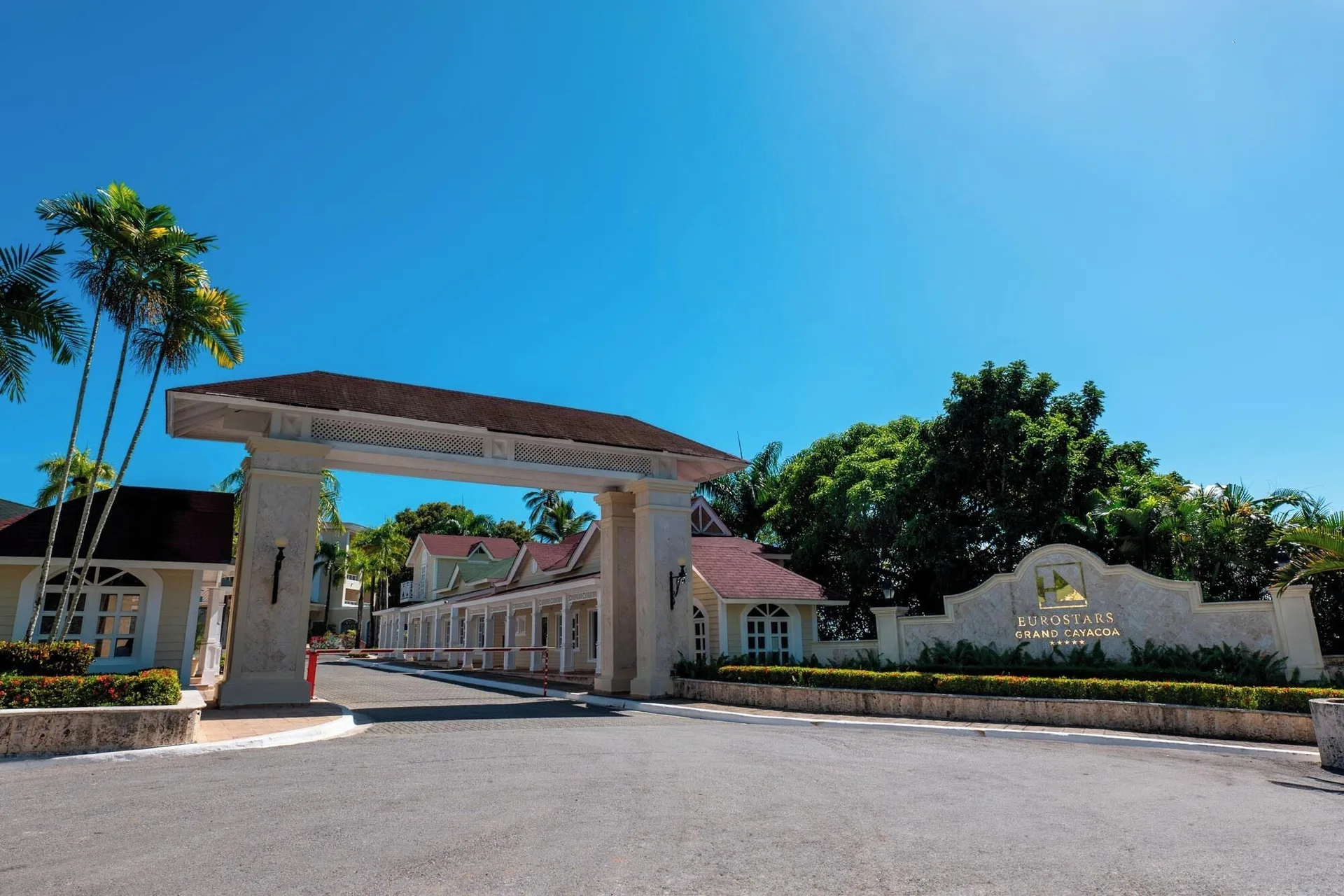 Entrance gate and hotel sign beside tropical landscaping at Eurostars Grand Cayacoa.