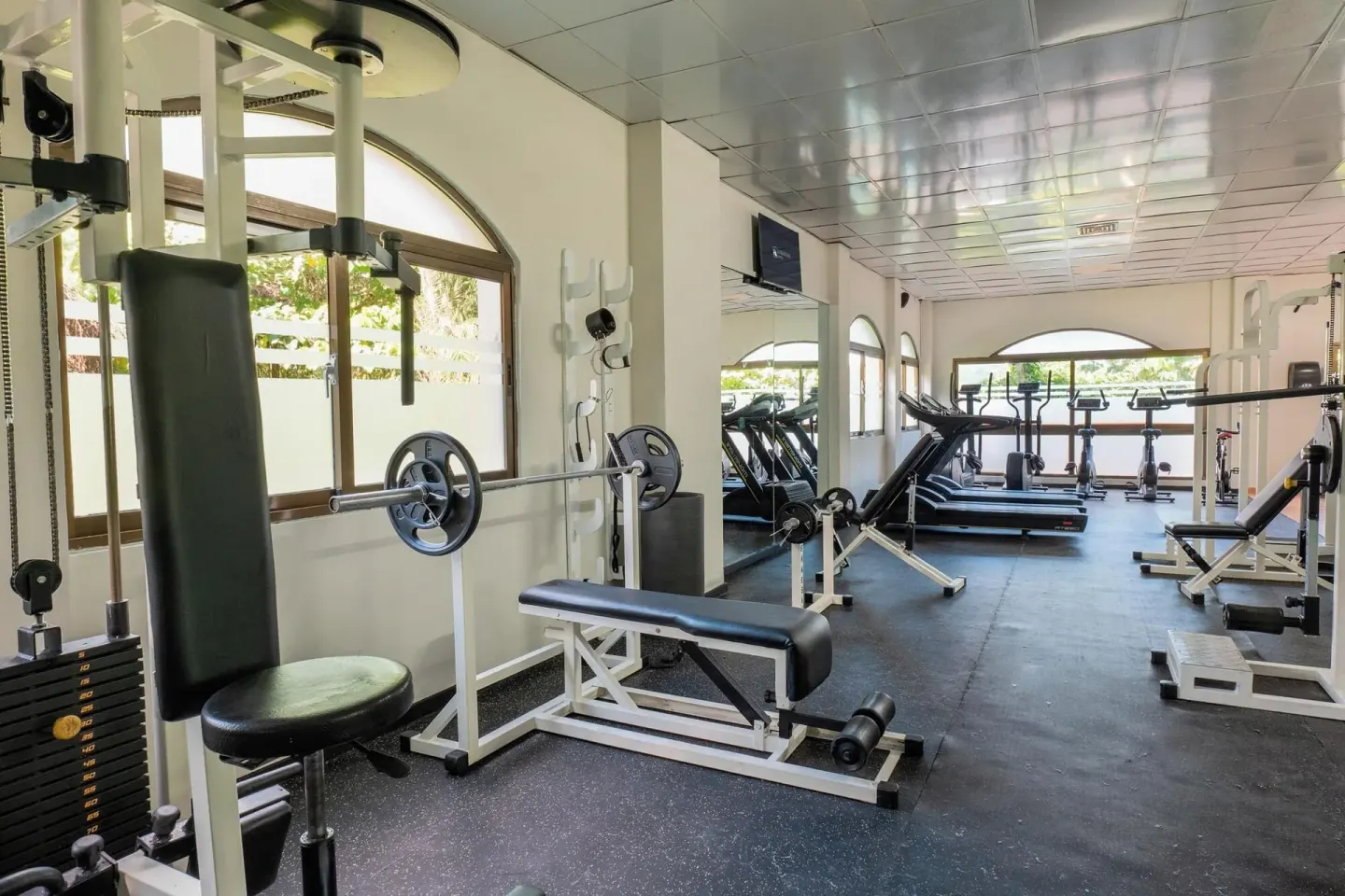 Fitness room with weight bench and cardio machines at Eurostars Grand Cayacoa.