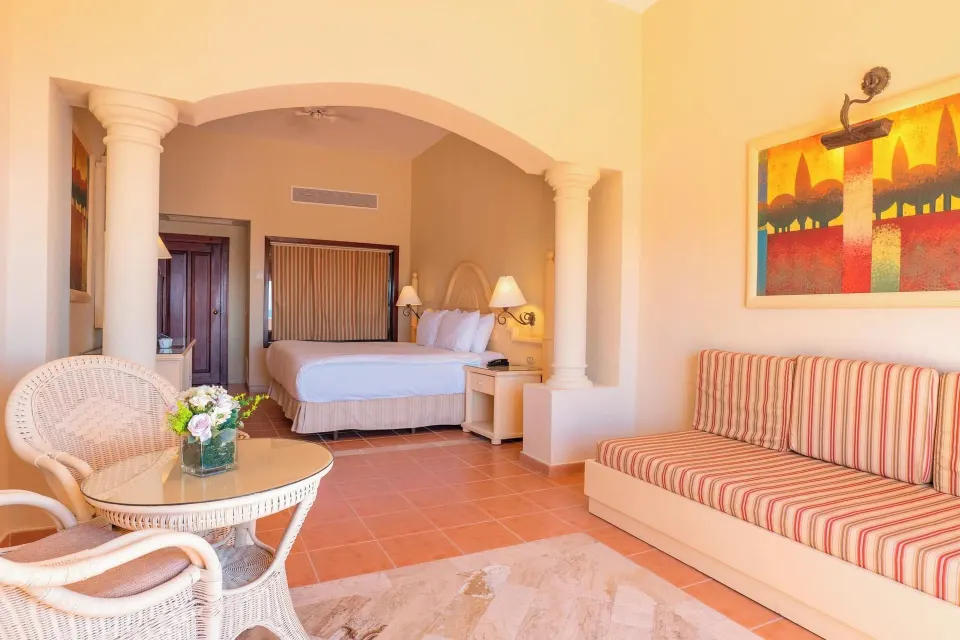 Guest room with king bed and striped sofa at Eurostars Grand Cayacoa.