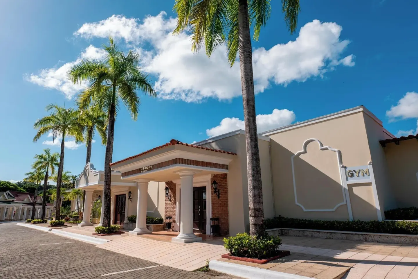 Exterior building entrance with palm trees and gym sign at Eurostars Grand Cayacoa.