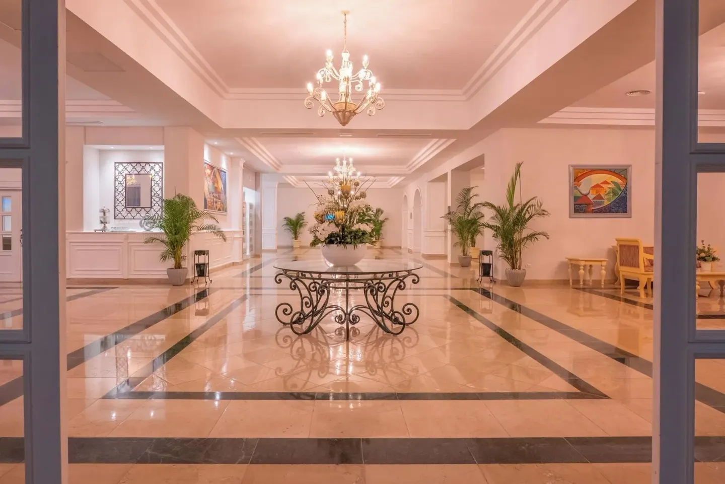 Elegant lobby corridor with chandeliers and floral table at Eurostars Grand Cayacoa.
