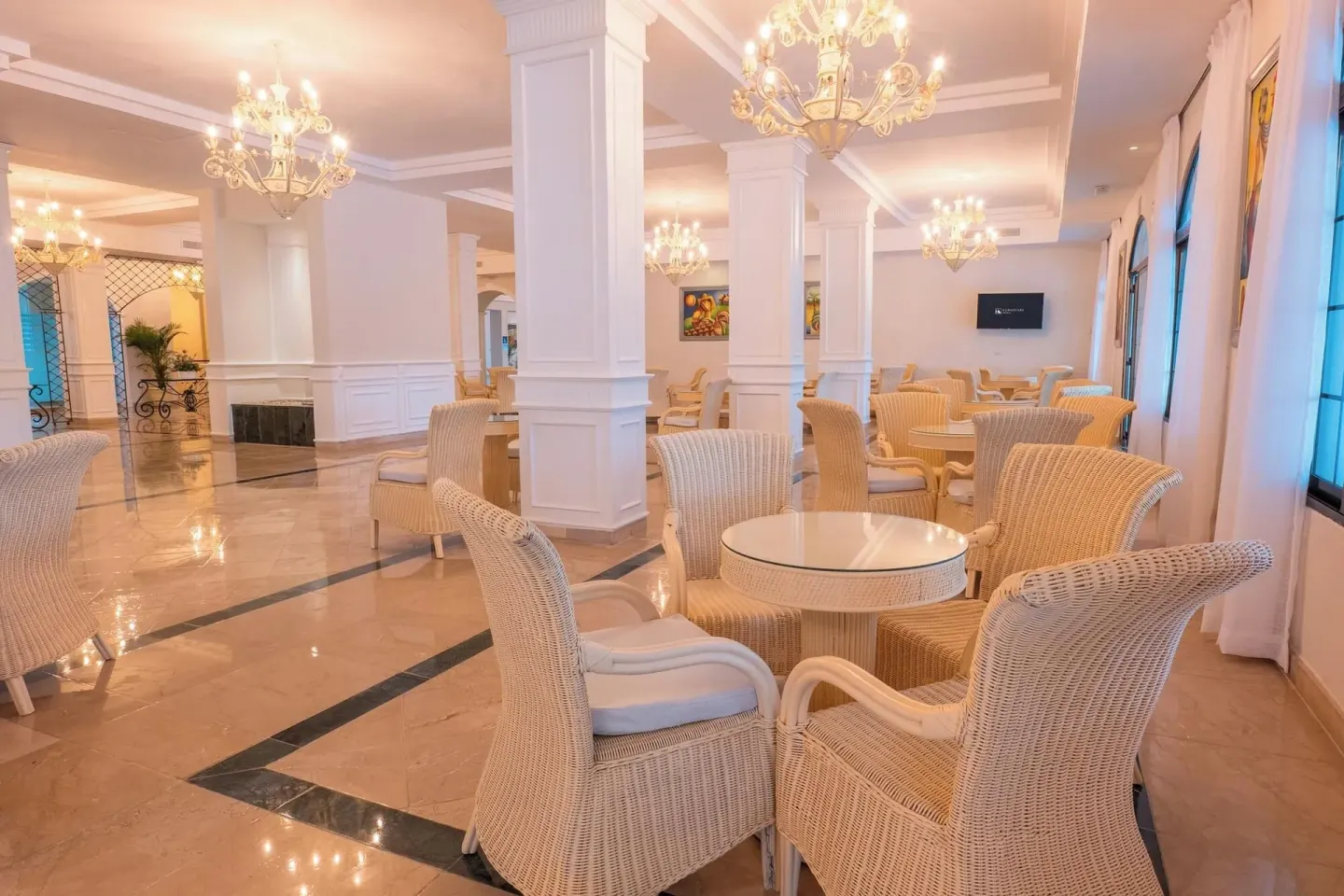 Lobby seating area with wicker chairs and round tables at Eurostars Grand Cayacoa.
