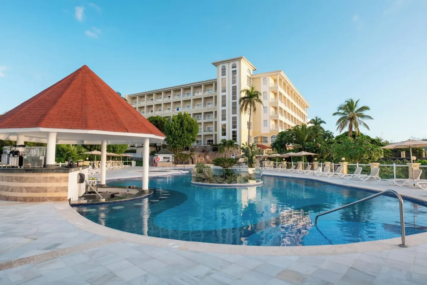 Main pool with swim-up bar pavilion and hotel building at Eurostars Grand Cayacoa.