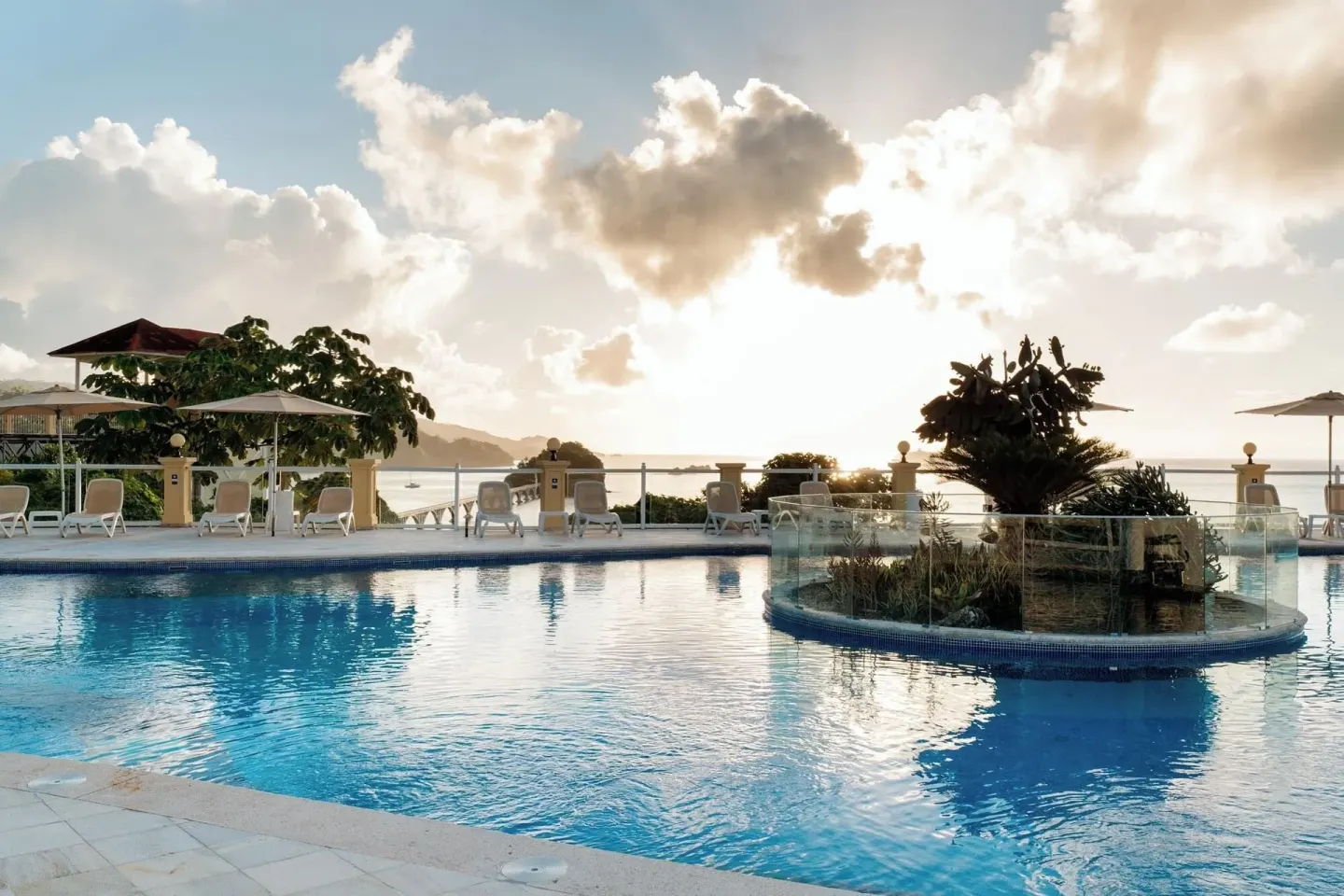 Resort pool at sunset with lounge chairs and ocean beyond at Eurostars Grand Cayacoa.
