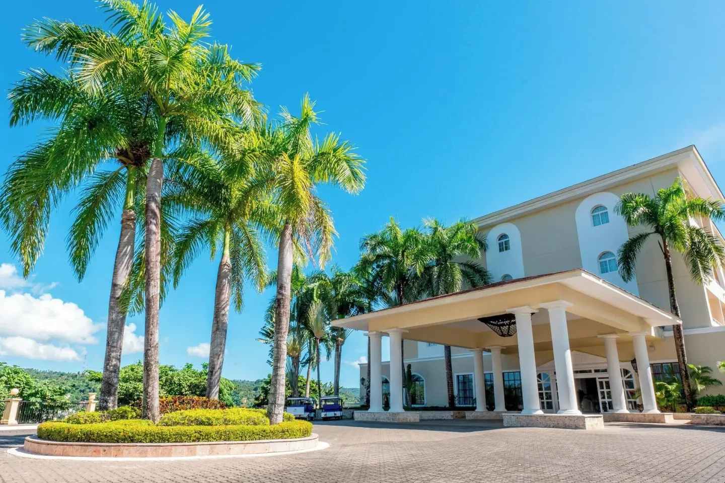 Palm-lined entrance driveway and porte cochere at Eurostars Grand Cayacoa.