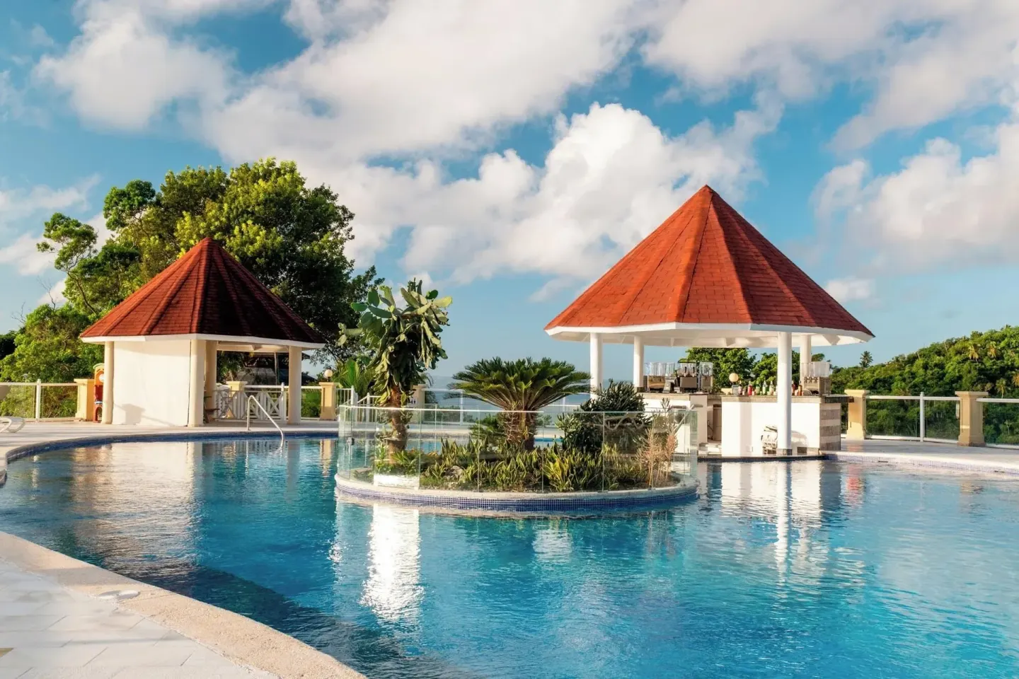 Pool with two red-roofed pavilions and tropical planting at Eurostars Grand Cayacoa.
