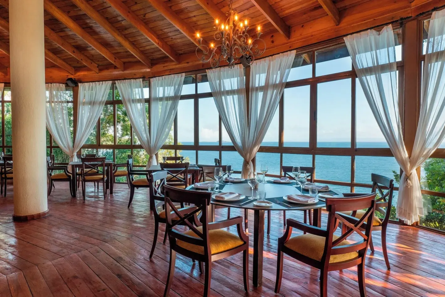 Ocean-view dining room with set tables and sheer curtains at Eurostars Grand Cayacoa.