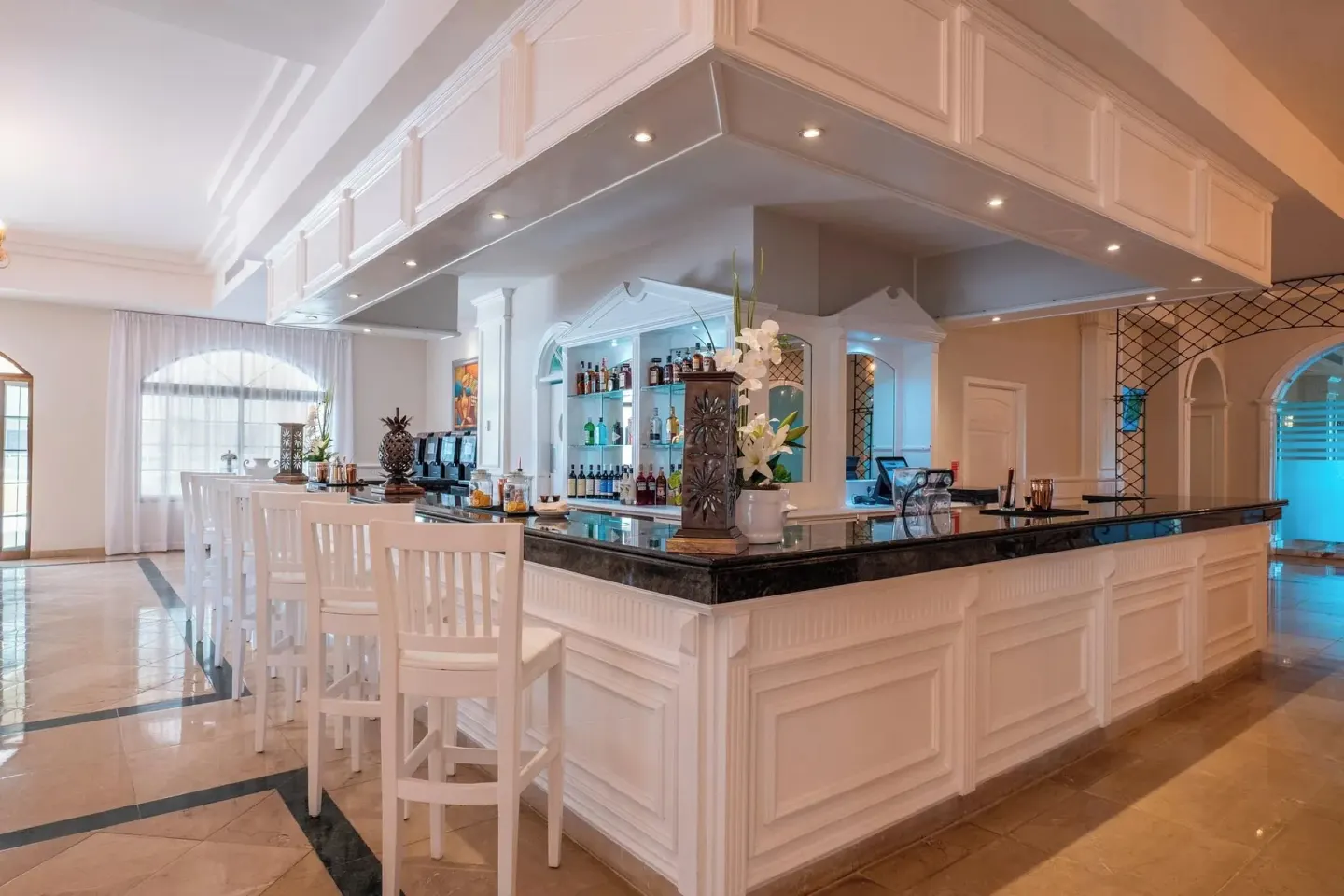 White lobby bar with high stools at Eurostars Grand Cayacoa.