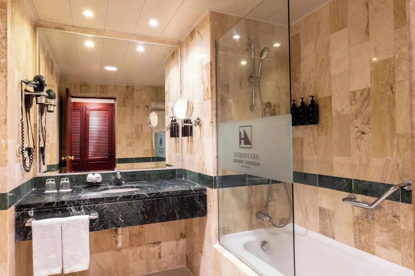 Marble bathroom with vanity and tub-shower in a Deluxe Room at Eurostars Grand Cayacoa.