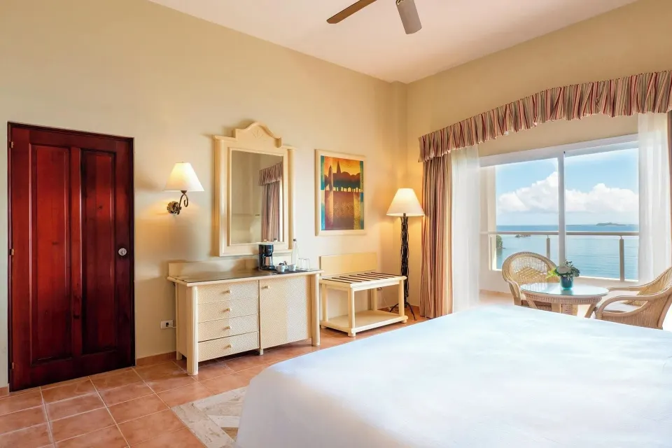 Deluxe Room Sea View with bed, dresser, and ocean window at Eurostars Grand Cayacoa.