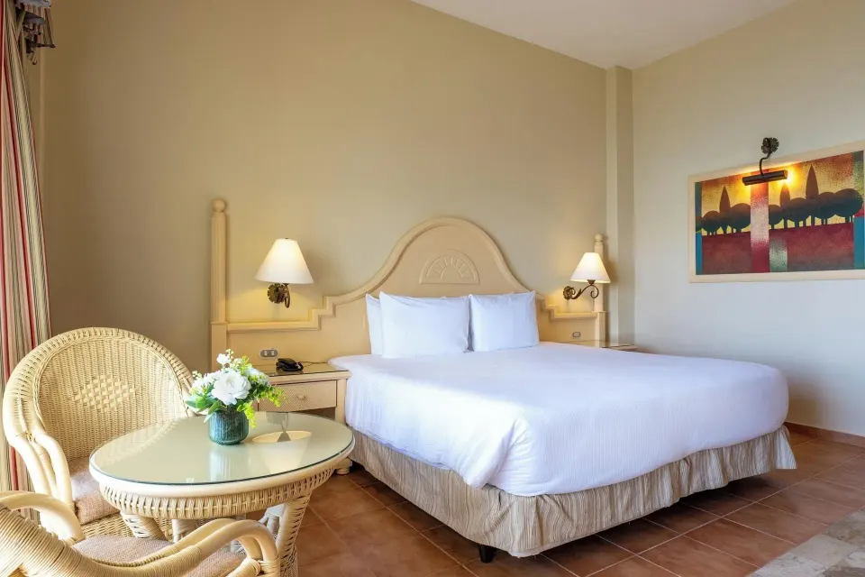 Deluxe Room Sea View bed and wicker seating at Eurostars Grand Cayacoa.
