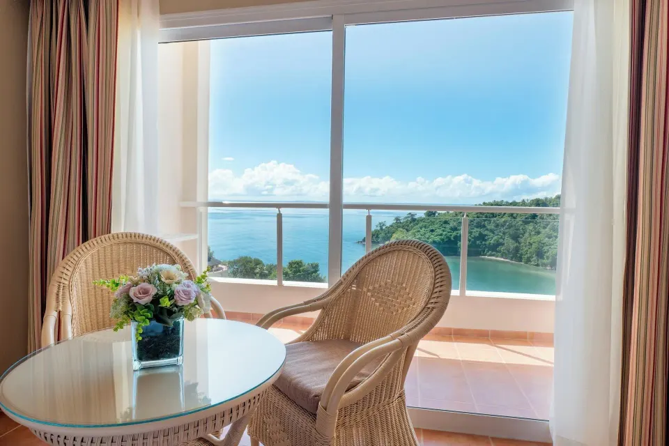 Wicker chairs and a balcony sea view in a Deluxe Room at Eurostars Grand Cayacoa.