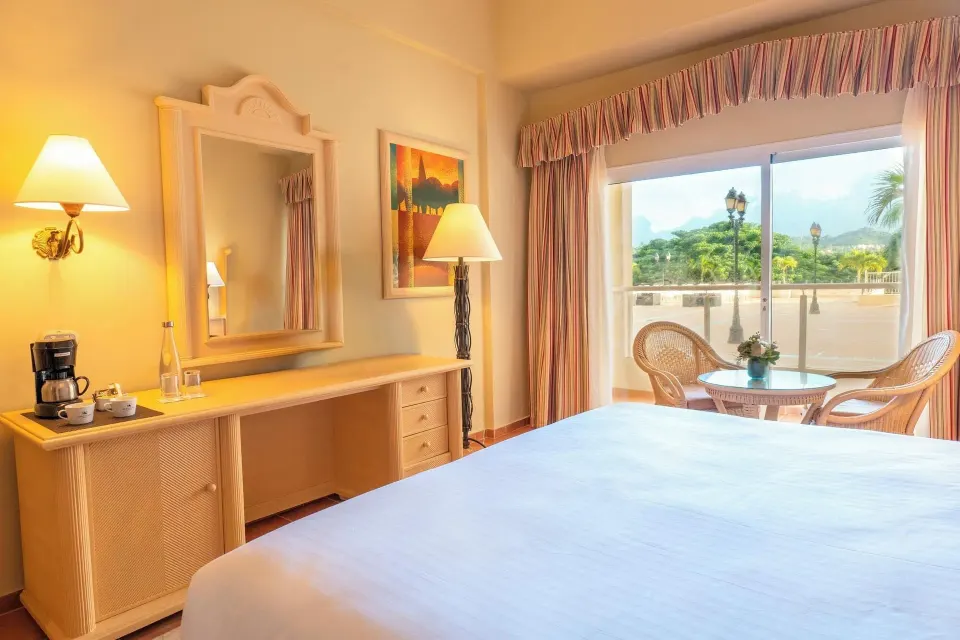 Deluxe Room with king bed, dresser, coffee maker, and terrace view at Eurostars Grand Cayacoa.