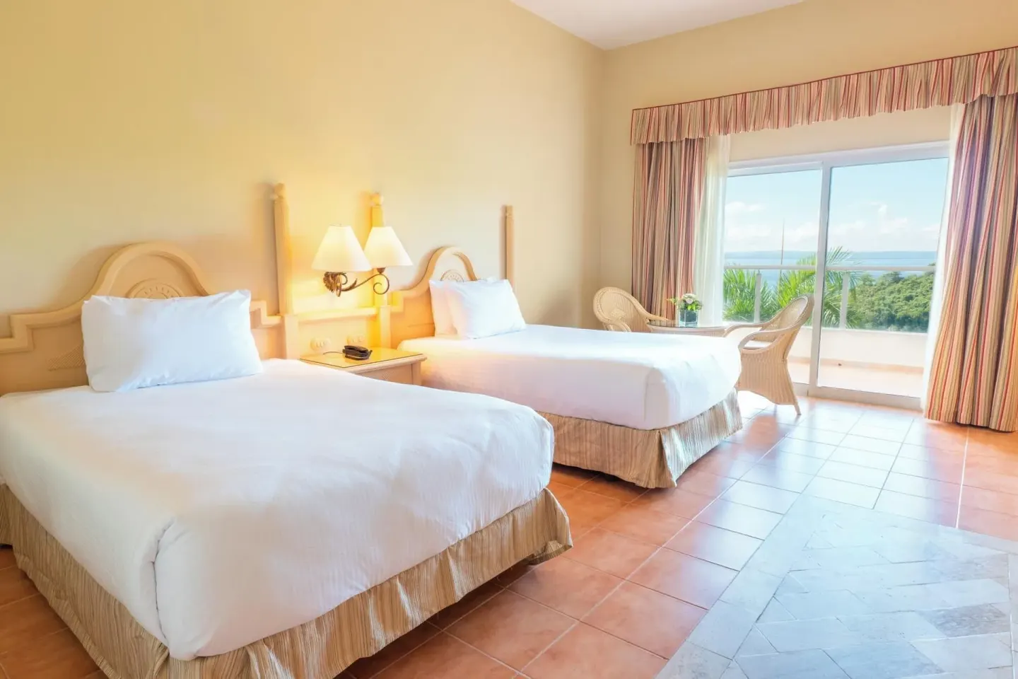 Deluxe Room with two beds, sliding glass doors, and ocean view at Eurostars Grand Cayacoa.