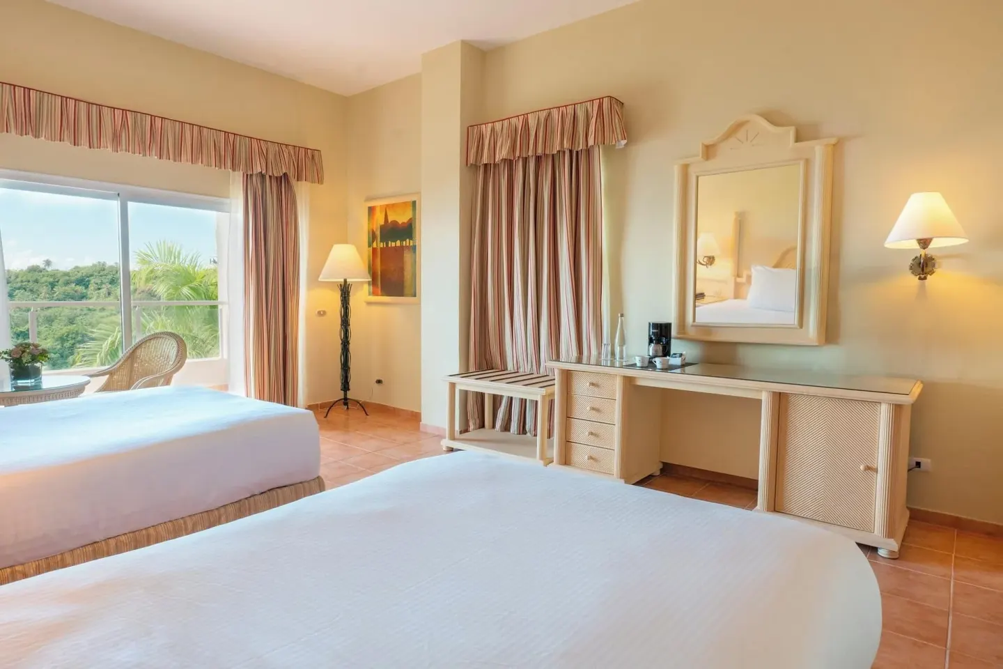 Deluxe Room with two beds, vanity, balcony doors, and greenery view at Eurostars Grand Cayacoa.