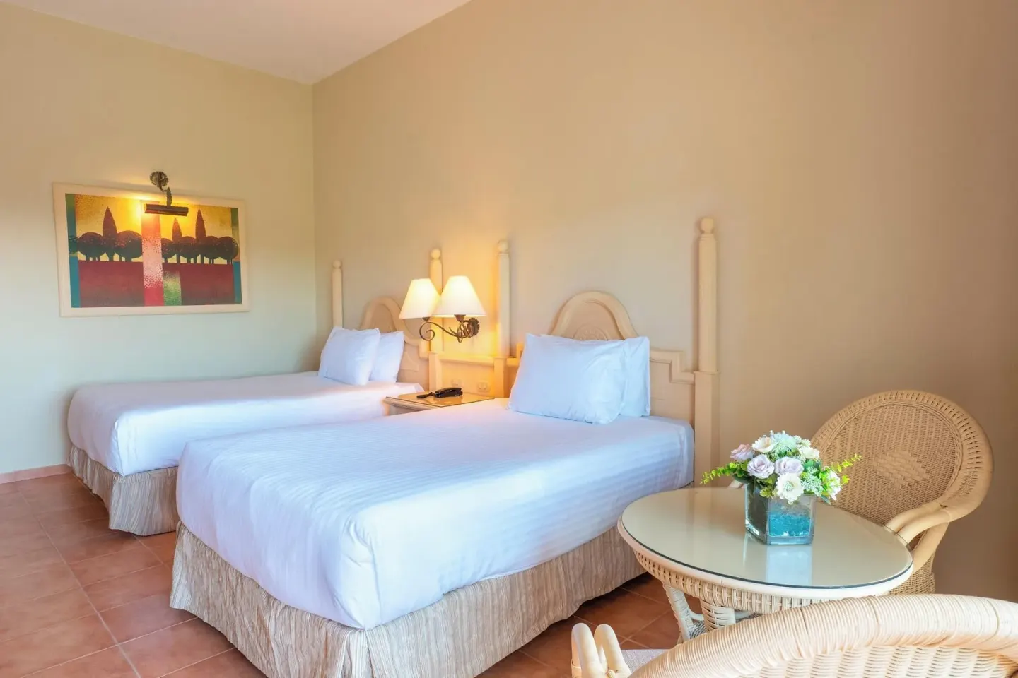 Deluxe Room with two beds, wicker chairs, and round table at Eurostars Grand Cayacoa.