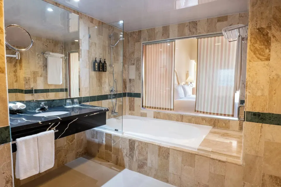 Room Sea View bathroom with bathtub and window to the bed at Eurostars Grand Cayacoa.