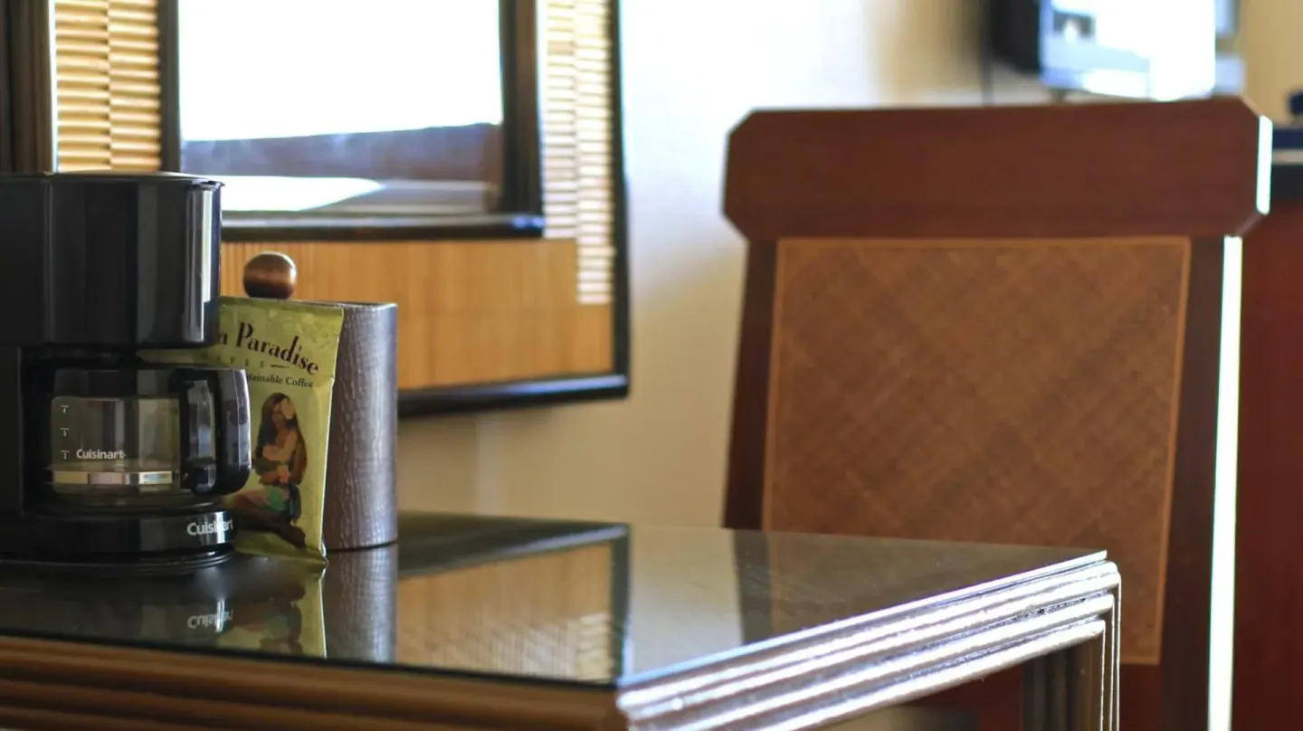 Coffee maker and coffee packet on a guest room table at Ewa Hotel Waikiki.