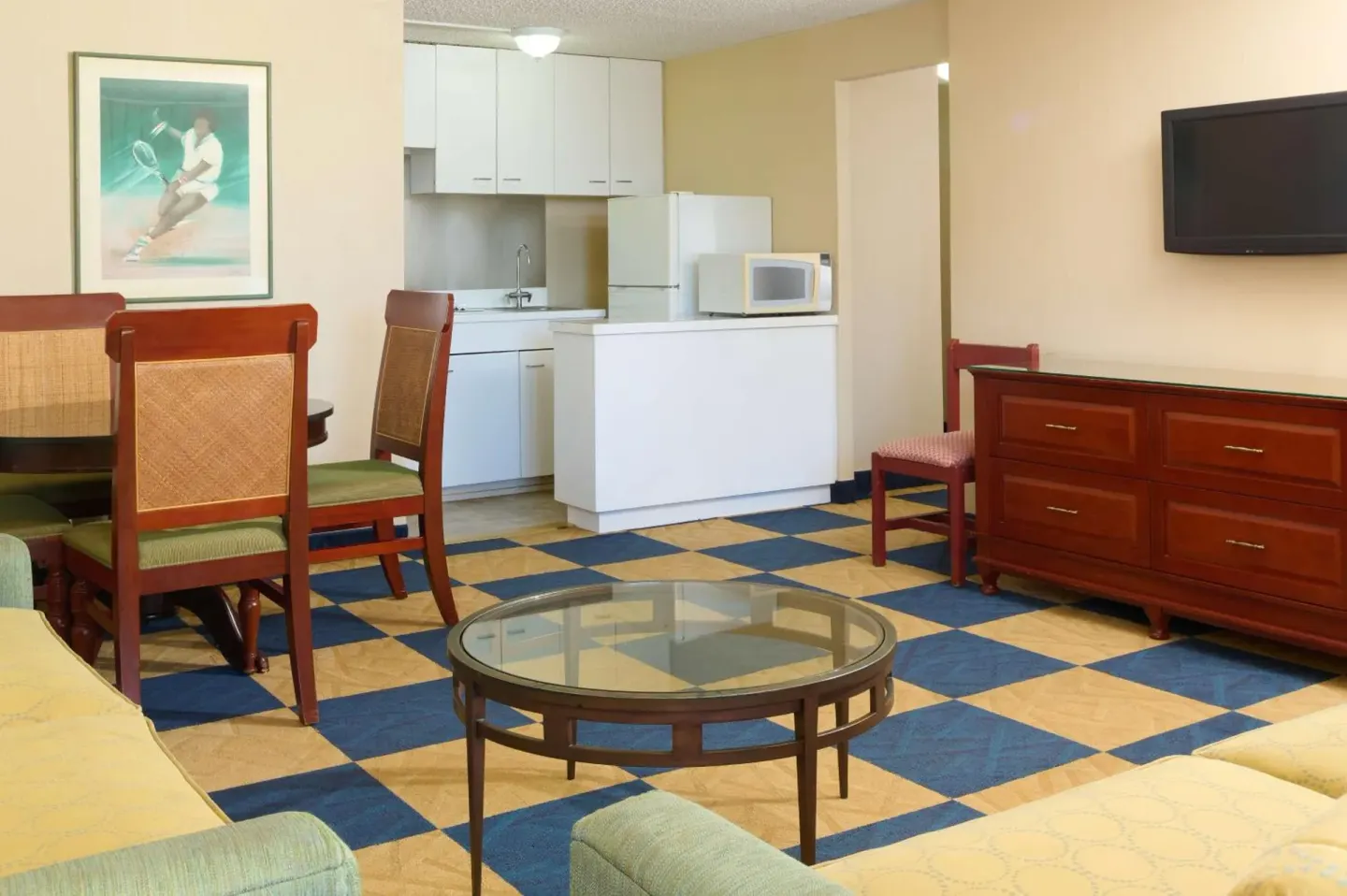 Guest room living area with kitchenette and TV at Ewa Hotel Waikiki.