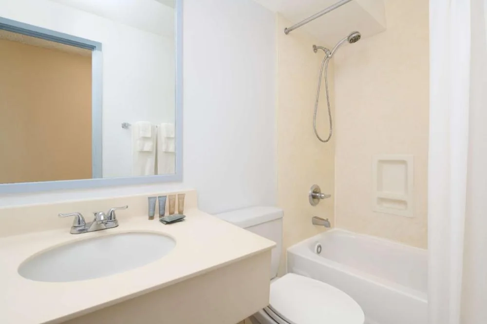 Moderate Room bathroom with sink, mirror and tub-shower at Ewa Hotel Waikiki.