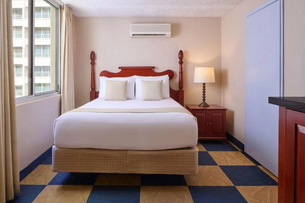Moderate Room with one bed, window, nightstand and lamp at Ewa Hotel Waikiki.