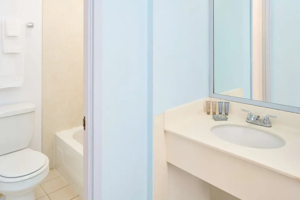 Studio kitchenette bathroom vanity, toilet, and tub at Ewa Hotel Waikiki.