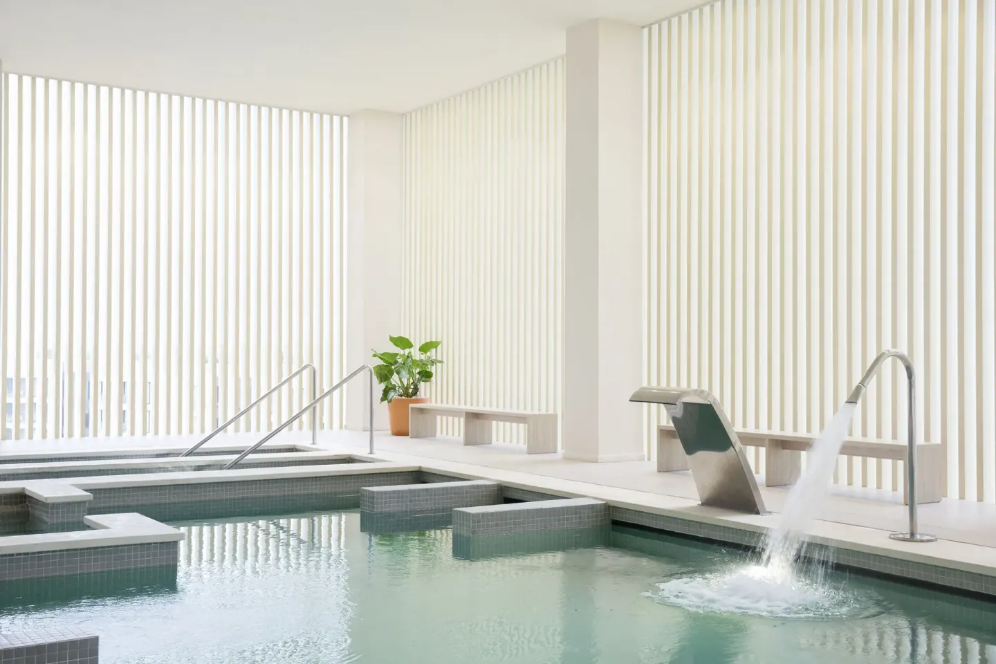 Indoor spa pool with water feature and lounge benches at Excellence El Carmen.