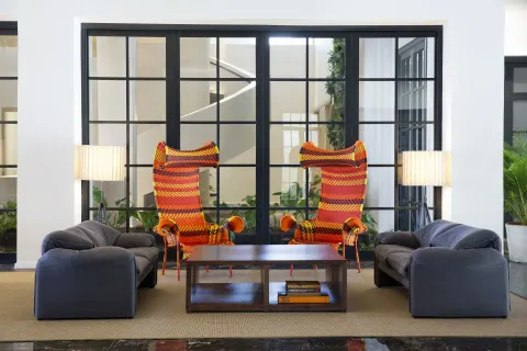 Lobby seating area with colorful high-back chairs at Excellence El Carmen.